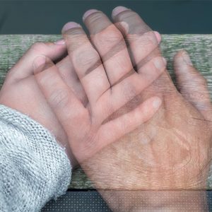 main d'adulte transparente sur une main d'enfant, contact avec un défunt