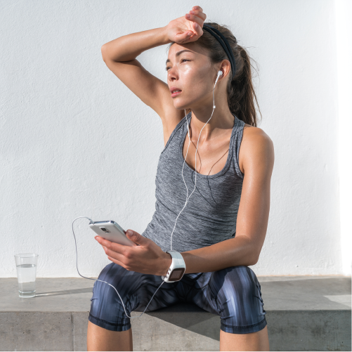 Femme qui s'essuit le front pendant le sport