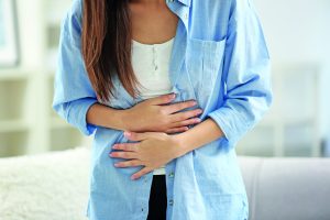 Young,Woman,Suffering,From,Abdominal,Pain,At,Home,,Closeup.,Gynecology