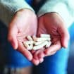 Closeup,Image,Of,A,Woman,Holding,White,Medicine,Capsules,In